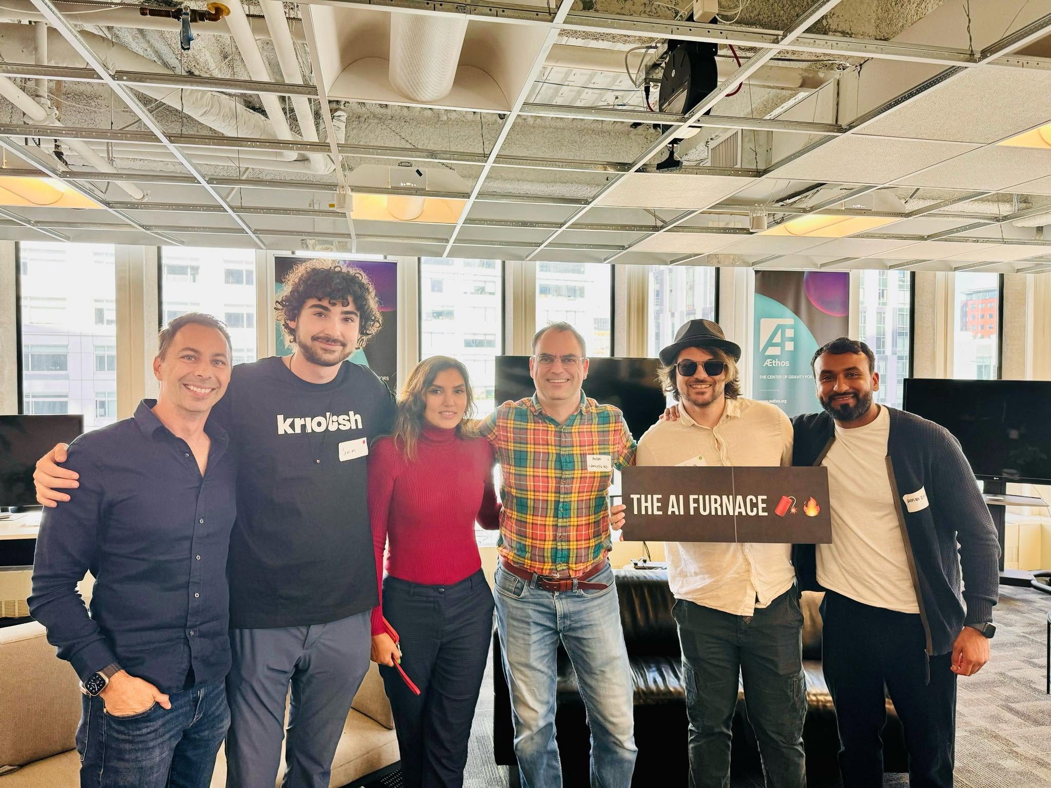 Dipali Trivedi with fellow speakers holding an AI Furnace sign at Æthos in Boston